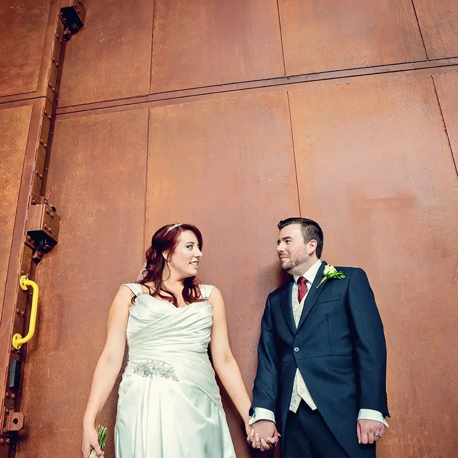 Bride and groom holding hands in front of Worcester architecture Bride and groom holding hands in front of Worcester architecture